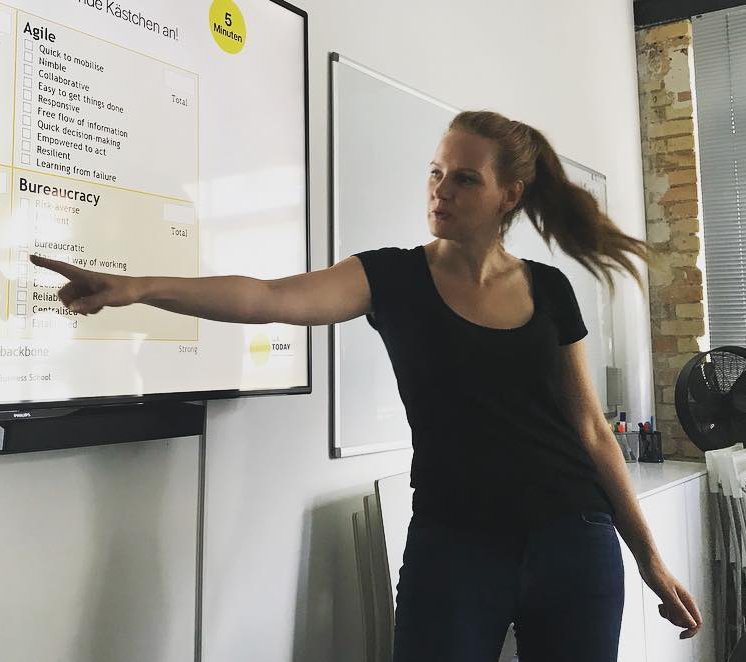Judith Biedenkapp moderiert einen Workshop und zeigt auf eine Übung zu agilem Arbeiten